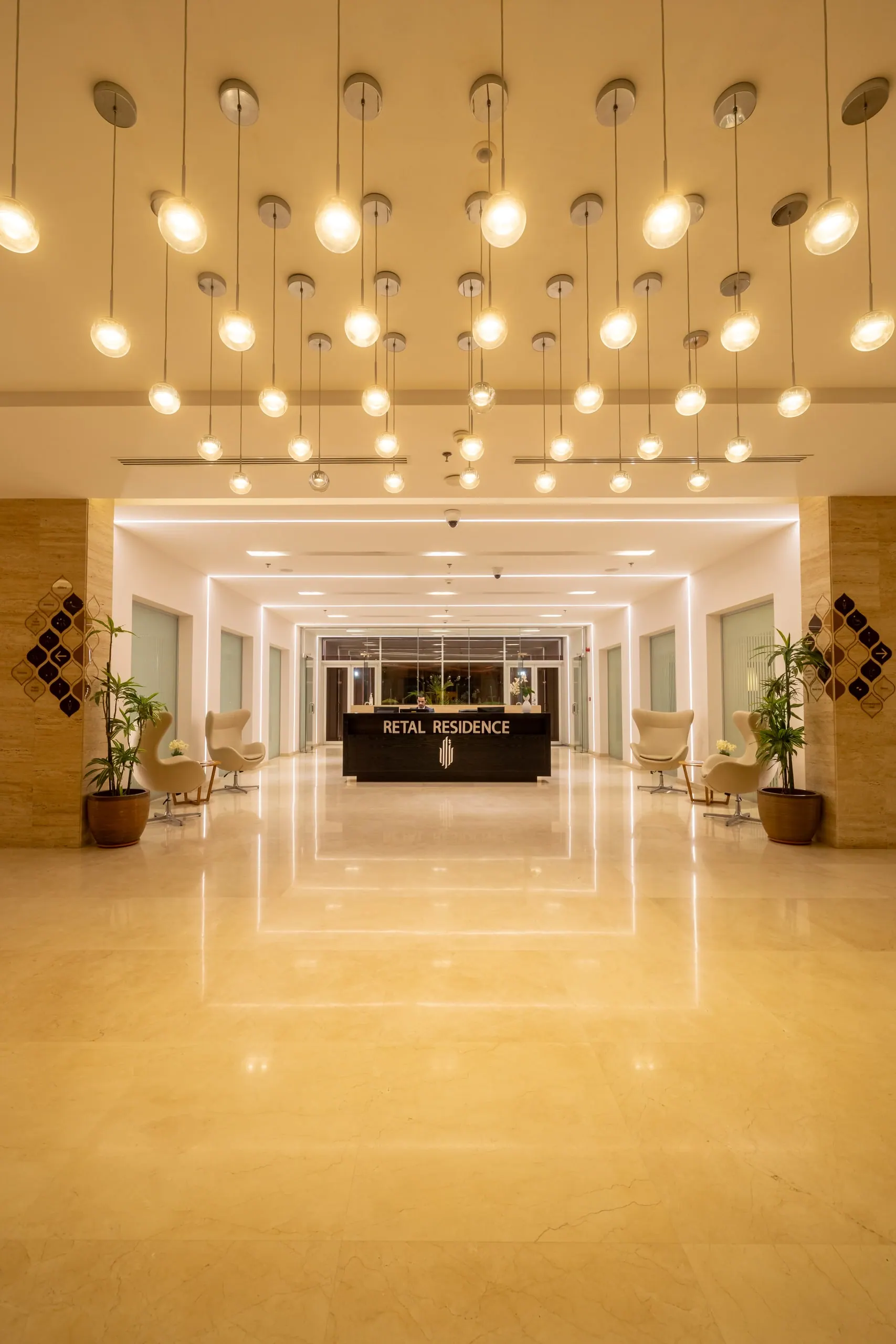 The outdoor pool at night, loungers along the lit Clubhouse terrace